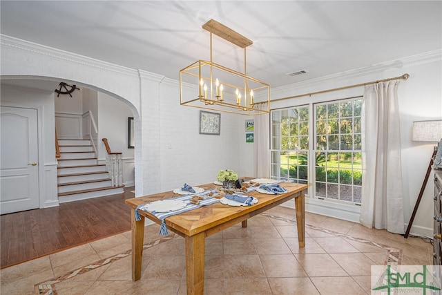 dining area with ornamental molding and light hardwood / wood-style floors