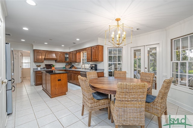 dining room with french doors, sink, crown molding, light tile patterned floors, and a chandelier