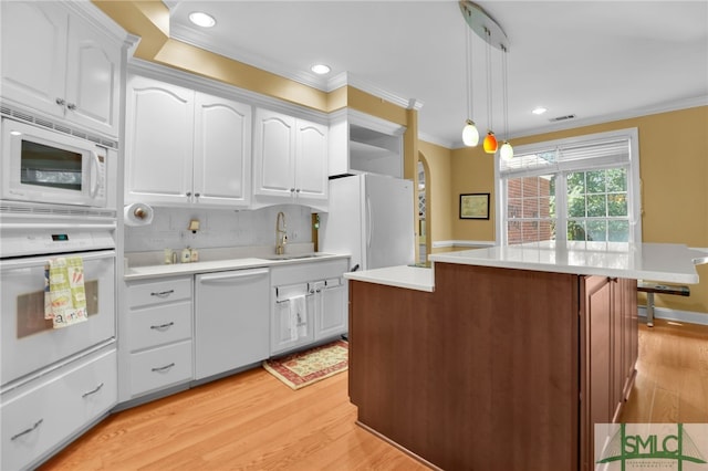 kitchen with light hardwood / wood-style flooring, a center island, hanging light fixtures, and white appliances