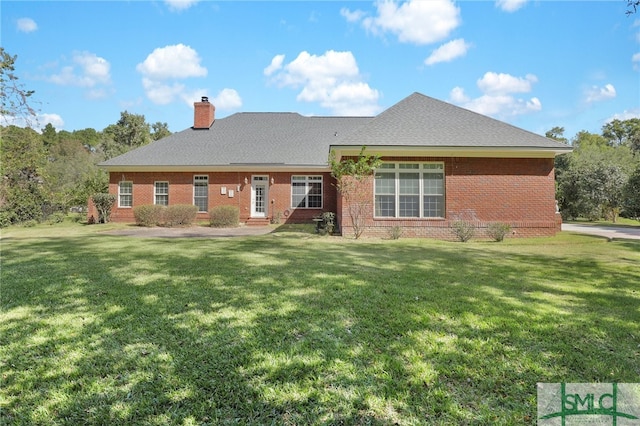 rear view of property featuring a lawn