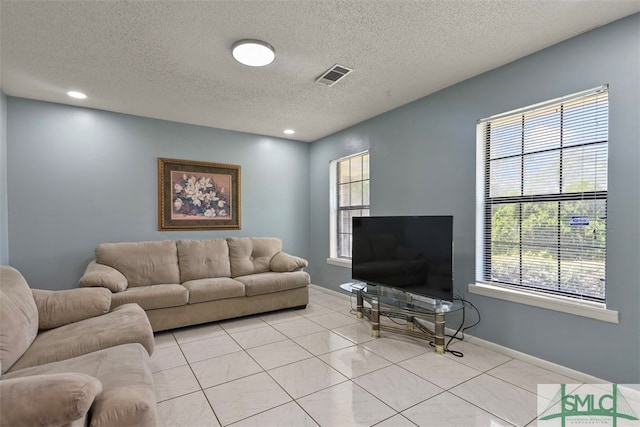 tiled living room with a healthy amount of sunlight and a textured ceiling