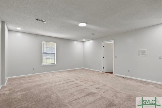 carpeted empty room with a textured ceiling