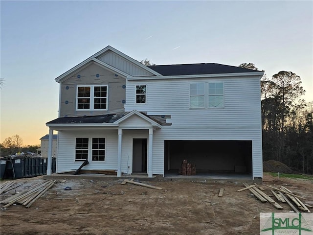 view of property with a porch and a garage