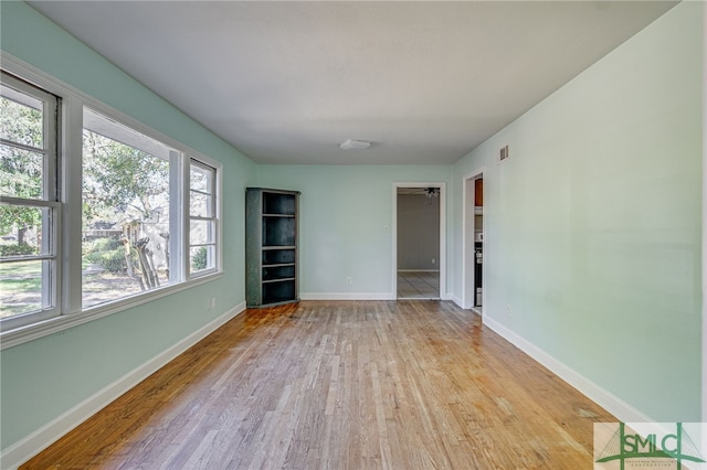 unfurnished room featuring light hardwood / wood-style floors and plenty of natural light