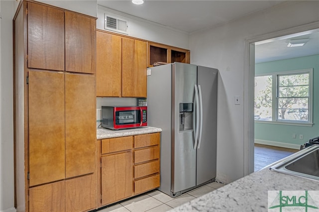 kitchen with sink, appliances with stainless steel finishes, crown molding, and light tile patterned floors