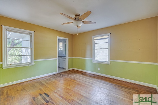 spare room with light wood-type flooring and ceiling fan