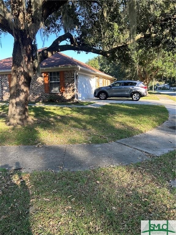 view of front of house featuring a garage and a front lawn