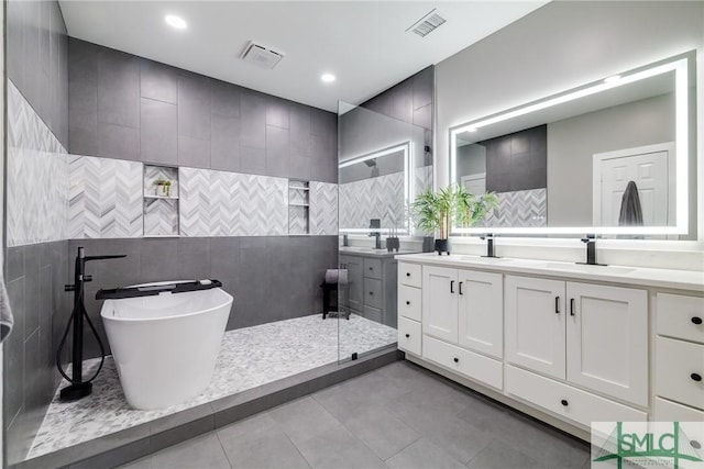 bathroom featuring shower with separate bathtub, vanity, tile patterned floors, and tile walls