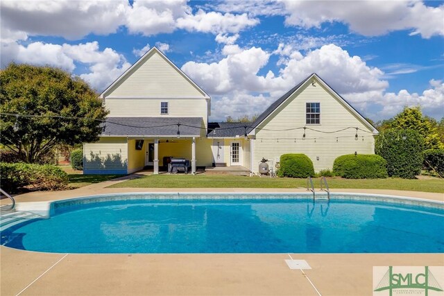 view of pool with a yard and a patio