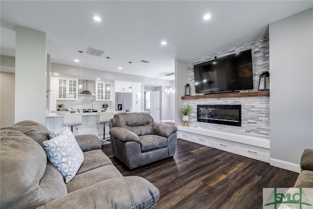 living room with dark hardwood / wood-style flooring and a large fireplace