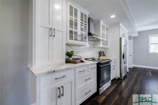 kitchen with wall chimney exhaust hood, white cabinetry, dark wood-type flooring, and appliances with stainless steel finishes