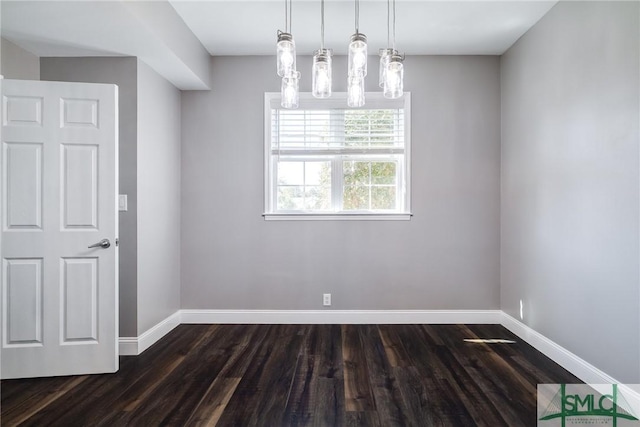 unfurnished dining area with a notable chandelier and dark hardwood / wood-style floors