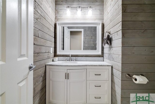 bathroom featuring vanity and wooden walls