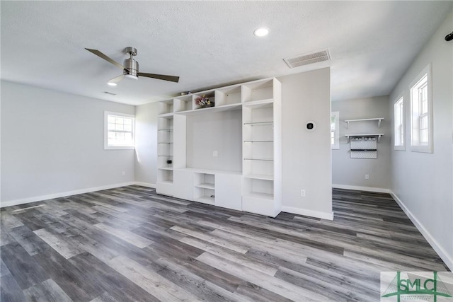 unfurnished living room featuring dark hardwood / wood-style floors, a textured ceiling, and ceiling fan