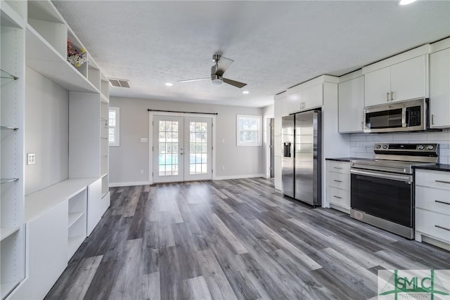 kitchen featuring french doors, stainless steel appliances, white cabinetry, and dark wood-type flooring