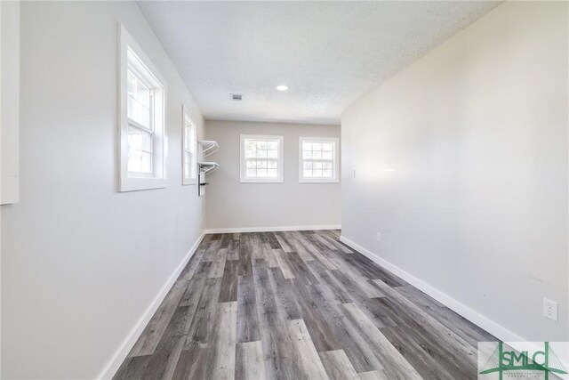 empty room with a textured ceiling and hardwood / wood-style flooring