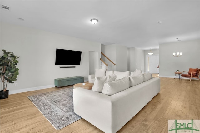 living room featuring light hardwood / wood-style flooring and an inviting chandelier