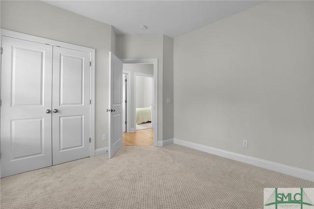 unfurnished bedroom with a closet and light carpet