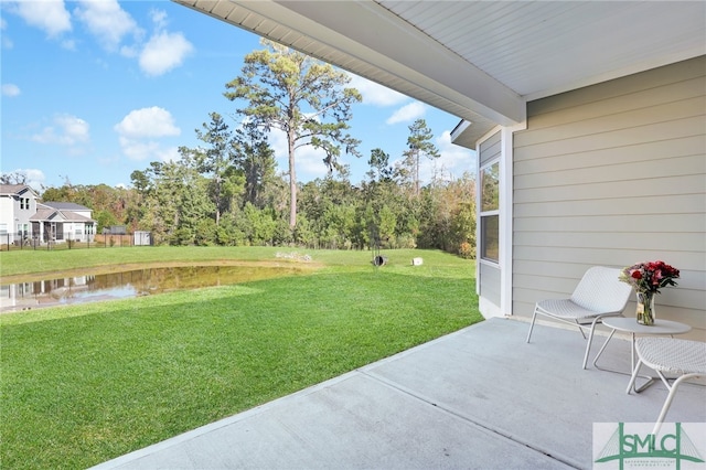 view of yard with a water view and a patio area