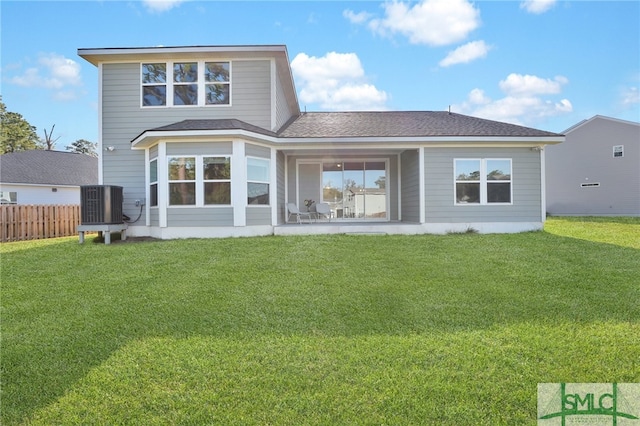 rear view of house with a patio, cooling unit, and a lawn