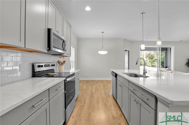 kitchen with gray cabinets, sink, appliances with stainless steel finishes, and light hardwood / wood-style floors