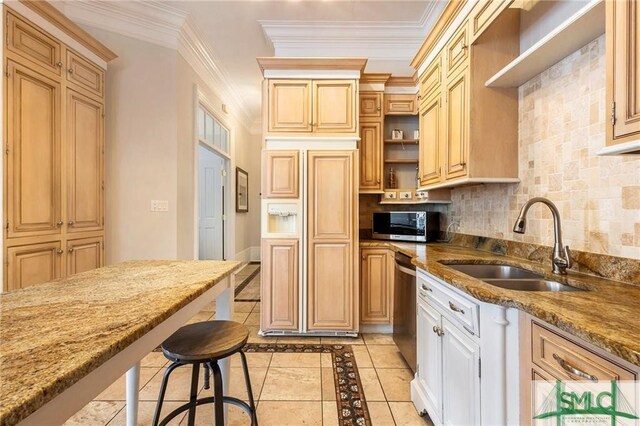 kitchen featuring light stone counters, sink, stainless steel appliances, and a kitchen bar