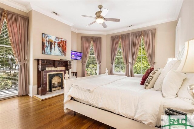 bedroom featuring hardwood / wood-style floors, ornamental molding, and ceiling fan