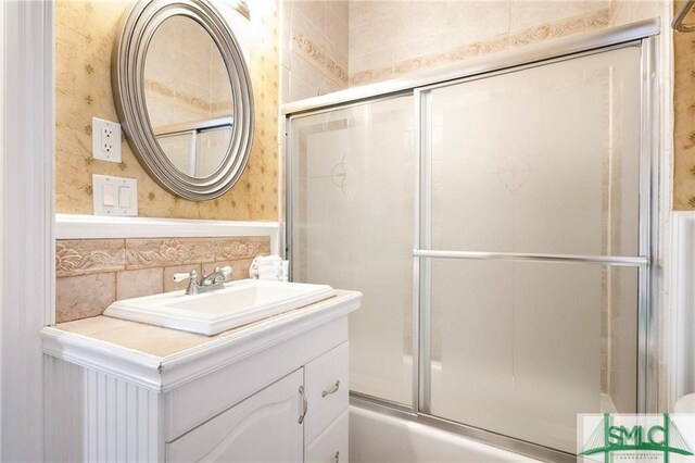 bathroom featuring enclosed tub / shower combo and vanity