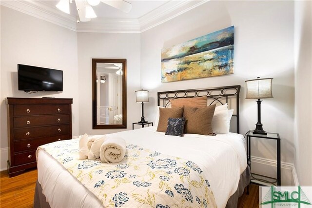 bedroom with hardwood / wood-style flooring and crown molding