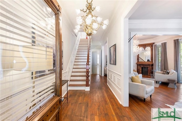 interior space with an inviting chandelier, crown molding, and dark hardwood / wood-style floors