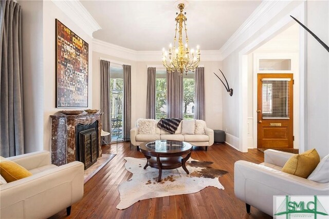 living room featuring hardwood / wood-style flooring, crown molding, and an inviting chandelier