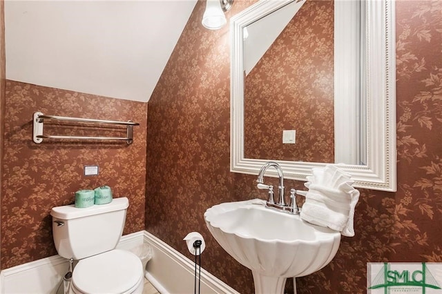 bathroom with vaulted ceiling, sink, and toilet