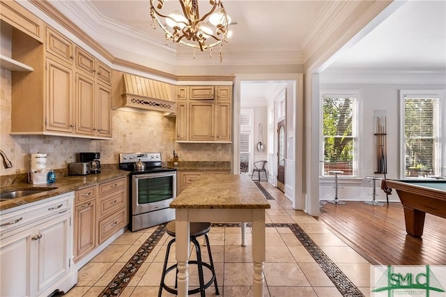 kitchen featuring pendant lighting, sink, backsplash, custom range hood, and stainless steel electric stove