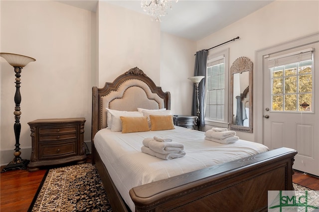 bedroom with a chandelier and dark hardwood / wood-style floors