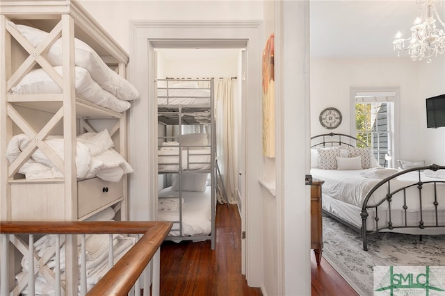 bedroom with dark wood-type flooring and a chandelier