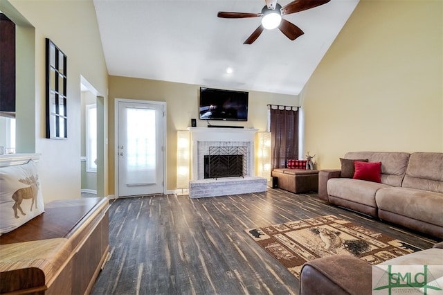 living room with ceiling fan, a fireplace, dark hardwood / wood-style floors, and vaulted ceiling