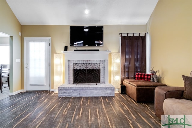 living room featuring dark hardwood / wood-style flooring, a fireplace, and lofted ceiling