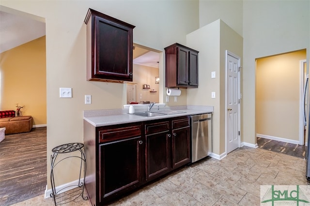 kitchen featuring dishwasher, light wood-type flooring, dark brown cabinetry, and sink