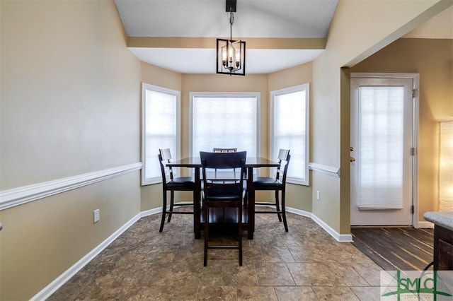 dining space featuring lofted ceiling and an inviting chandelier