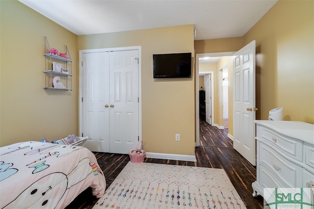 bedroom with dark hardwood / wood-style flooring and a closet