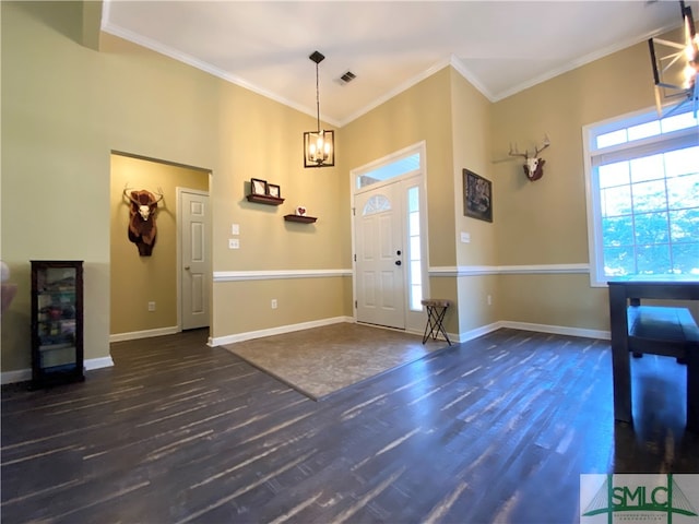 entrance foyer featuring crown molding, dark wood-type flooring, and an inviting chandelier