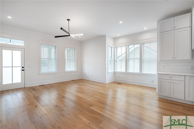 unfurnished dining area featuring light hardwood / wood-style flooring and ceiling fan