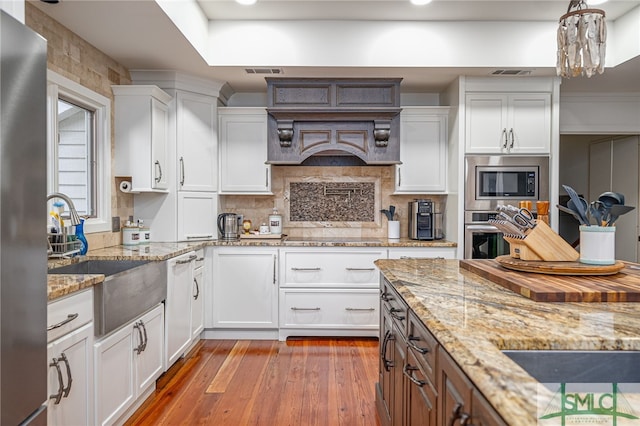 kitchen featuring white cabinetry, appliances with stainless steel finishes, visible vents, and light wood-style flooring