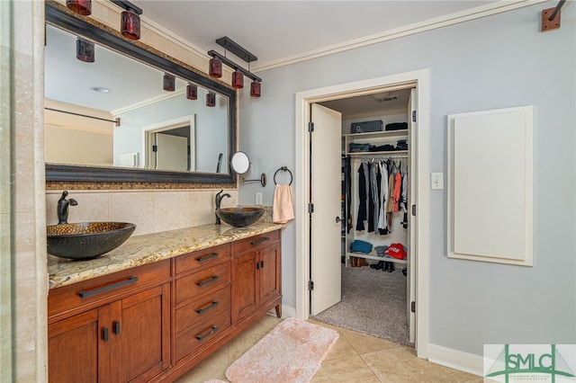 full bath featuring tasteful backsplash, tile patterned floors, crown molding, and a sink
