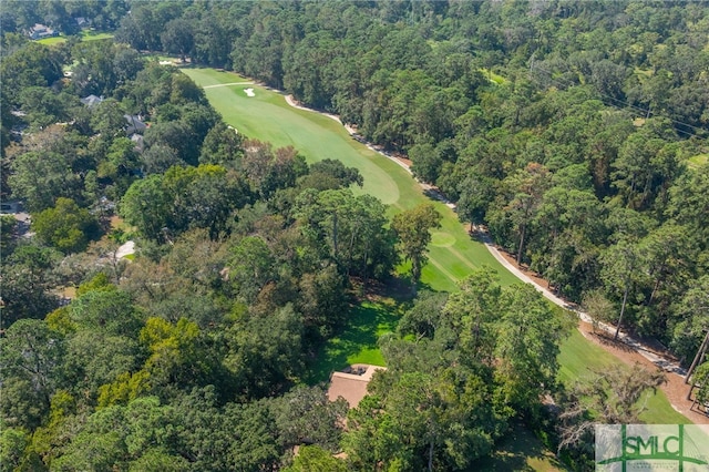 aerial view featuring a forest view and golf course view