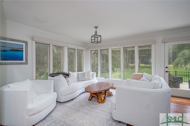 sunroom / solarium with crown molding, wood finished floors, and an outdoor living space