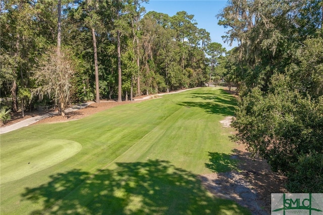view of community with a yard and golf course view