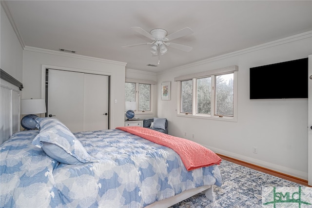 bedroom with a closet, ornamental molding, wood-type flooring, and ceiling fan