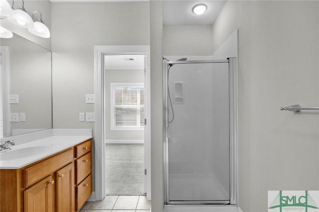 bathroom featuring vanity, a shower with shower door, and tile patterned flooring