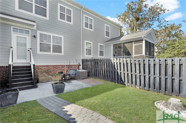 back of house featuring a yard, a sunroom, cooling unit, and a patio area